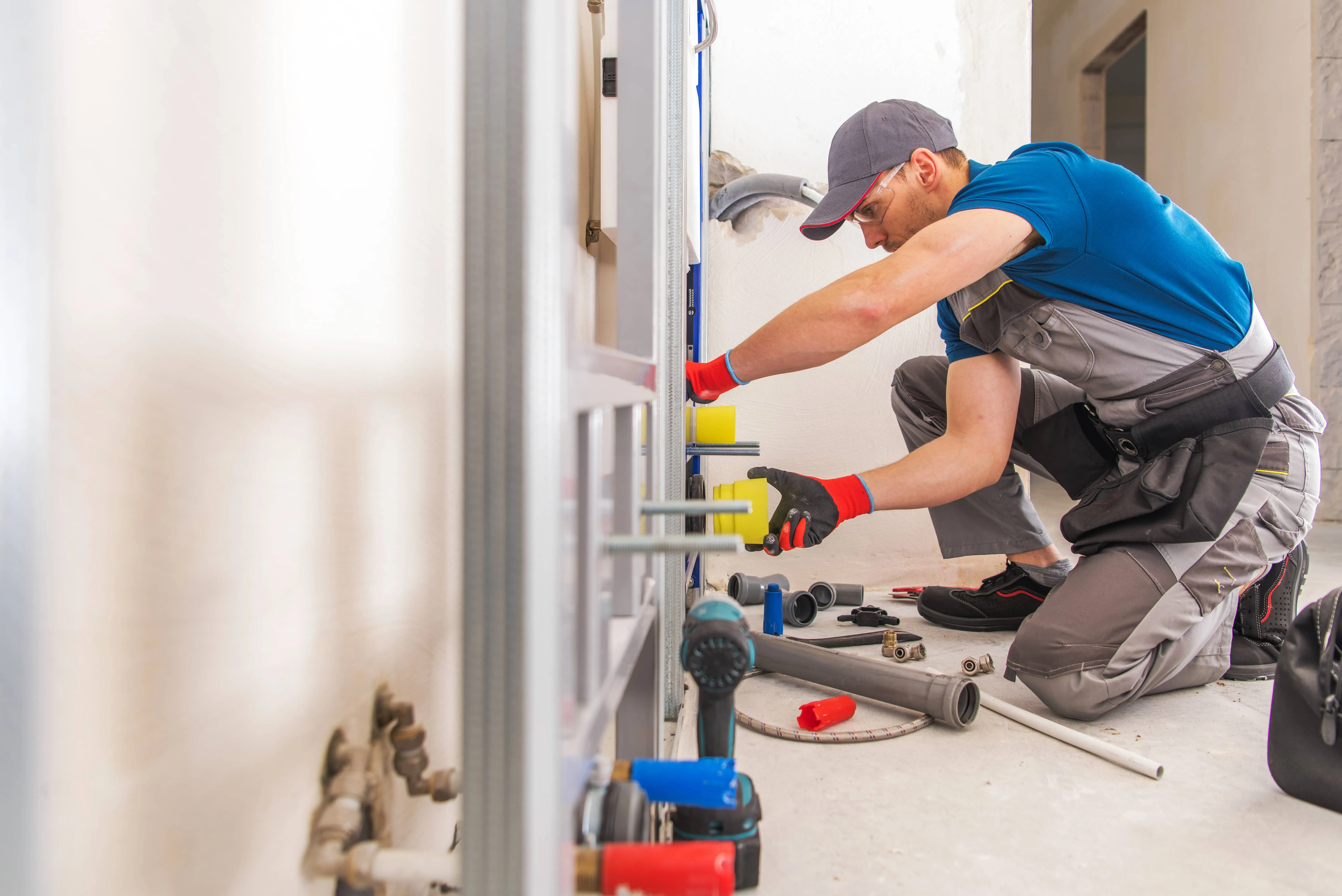 Plumber fitting and checking pipe connections during a leak inspection